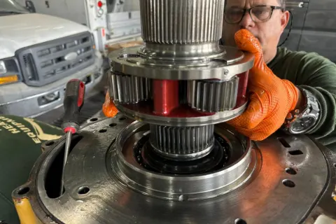 Heavy-equipment undercarriage components being serviced — photo 1